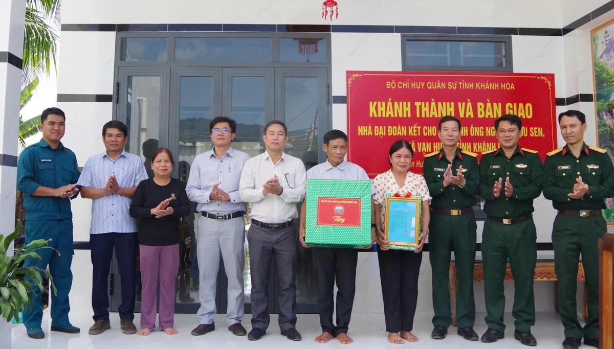 Tặng quà cho gia đình chính sách tại lễ bàn giao nhà Đại đoàn kết. (ảnh X.H)