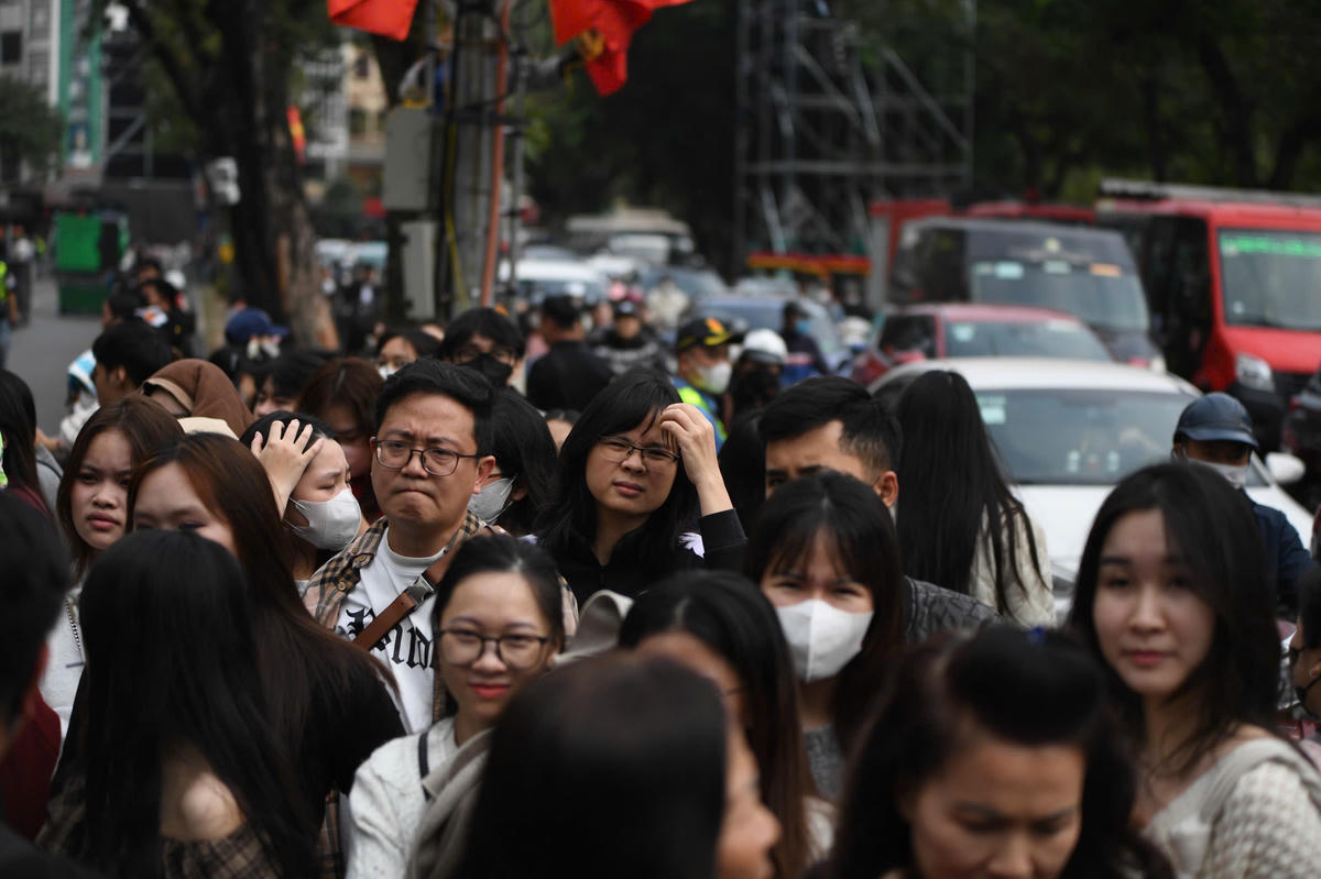 Lượng người đổ về khu vực trung tâm tăng nhanh. Xung quanh Gươm dần ken đặc người đi bộ, phần lớn là nhóm bạn trẻ và gia đình tranh thủ đến sớm để ghi lại những bức ảnh đầu tiên của ngày cuối năm. Ảnh: Phạm Sỹ.