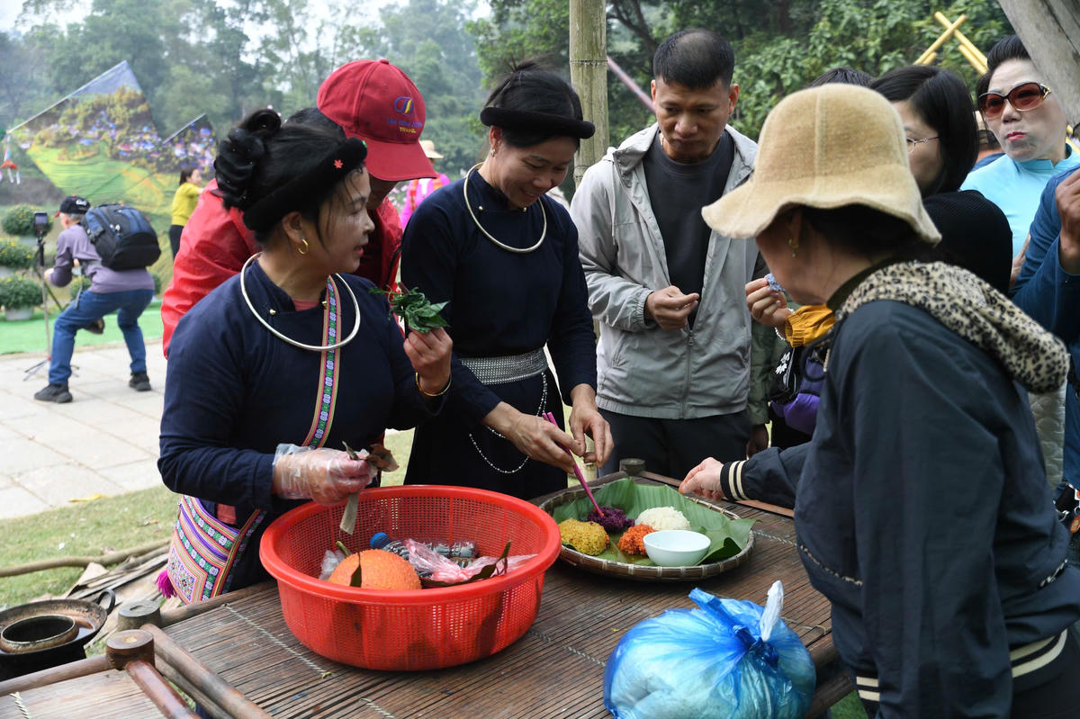 Du khách thưởng thức món xôi ngũ sắc cùng bà con đồng bằng vùng cao. Ảnh: Phạm Sỹ.