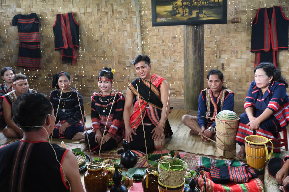 Trong không khí trang nghiêm trước sự chứng kiến của dân làng và gia đình hai họ, người đại diện làm lễ khấn báo với thần bản mệnh của cộng đồng. Ảnh: Phạm Sỹ.
