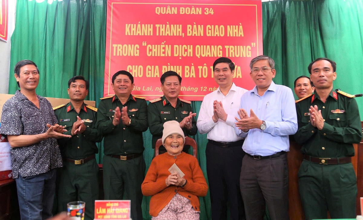 Bà Tô Thị Sửa (ở giữa) vui mừng khi có ngôi nhà mới. Ảnh: C.V. 