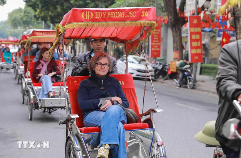 Du khách nước ngoài thích thú với khí hậu mát lạnh của Thủ đô Hà Nội. (Ảnh: Phan Phương/TTXVN).. 