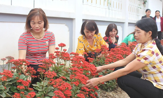 Hội viên phụ nữ chăm sóc các tuyến đường hoa, góp phần thực hiện có hiệu quả cuộc vận động “Xây dựng gia đình 5 không, 3 sạch”. Ảnh: Hồng Huế.