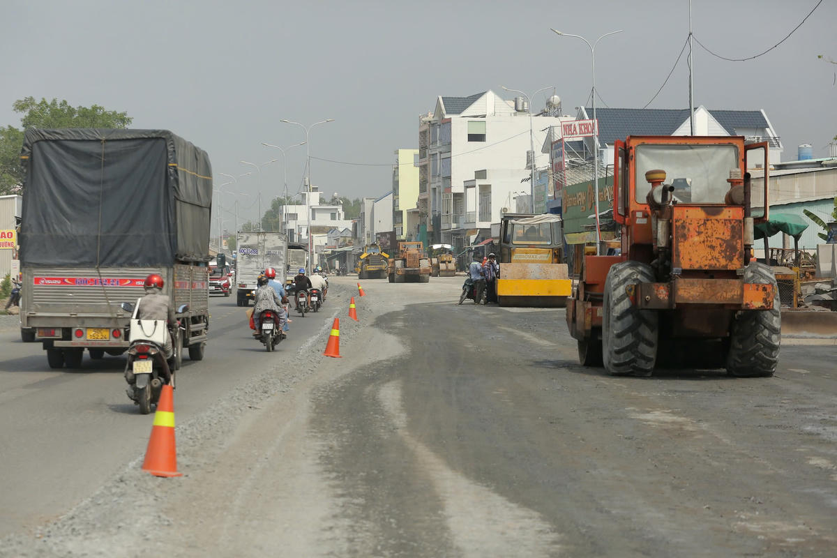 Do đây là trục giao thông lớn, mật độ phương tiện cao nên người dân vừa lưu thông bên cạnh máy móc thi công. Ảnh: Đ.Xá.
