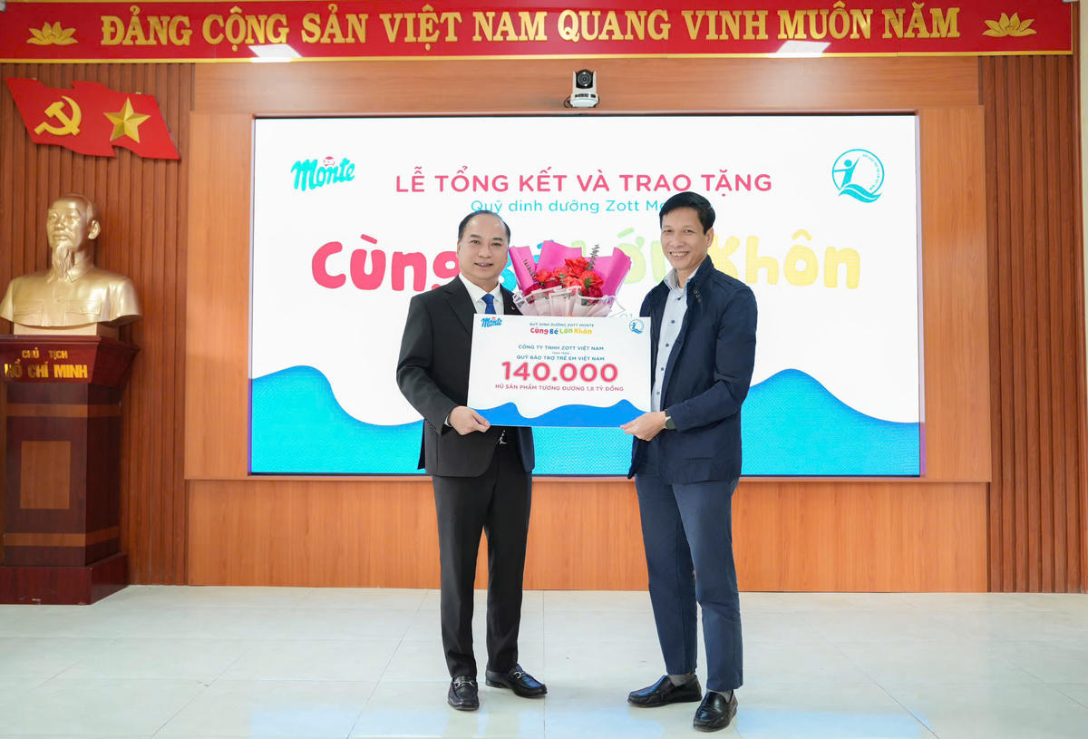 Ông Đinh Tiến Hải - Giám đốc Quỹ BTTEVN (bên trái) tiếp nhận 140.000 hũ sản phẩm thành quả gây quỹ của chương trình Quỹ dinh dưỡng từ ông Bùi Quốc Hùng - Phó Tổng Giám đốc Zott Việt Nam. Ảnh: Minh Long