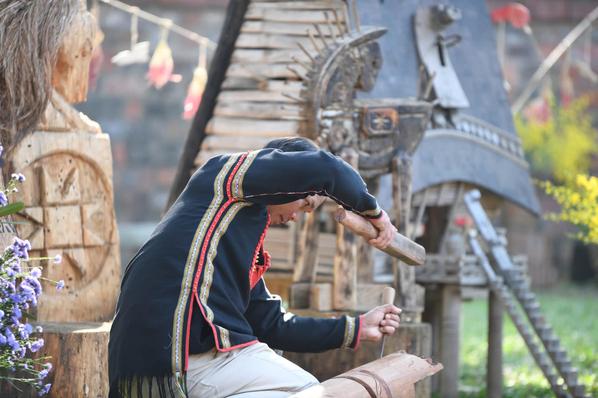 Nghệ nhân Y Bhiông Buôn Yă tạc tượng ngựa tại không gian Văn Miếu - Quốc Tử Giám. Ảnh: Phạm Sỹ.