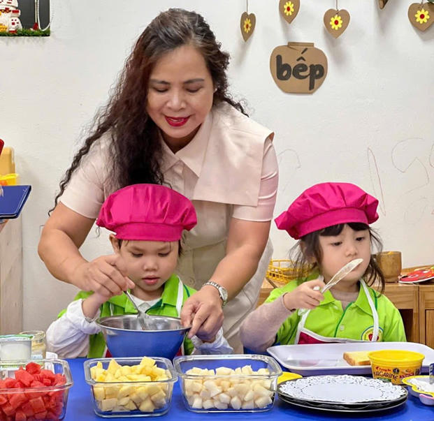 Cô giáo Nguyễn Thị Vân Thoa – Chủ tịch Hội đồng kiêm Hiệu trưởng Trường Mầm non Hoa Hồng hướng dẫn các con học sinh thực hiện món ăn yêu thích.