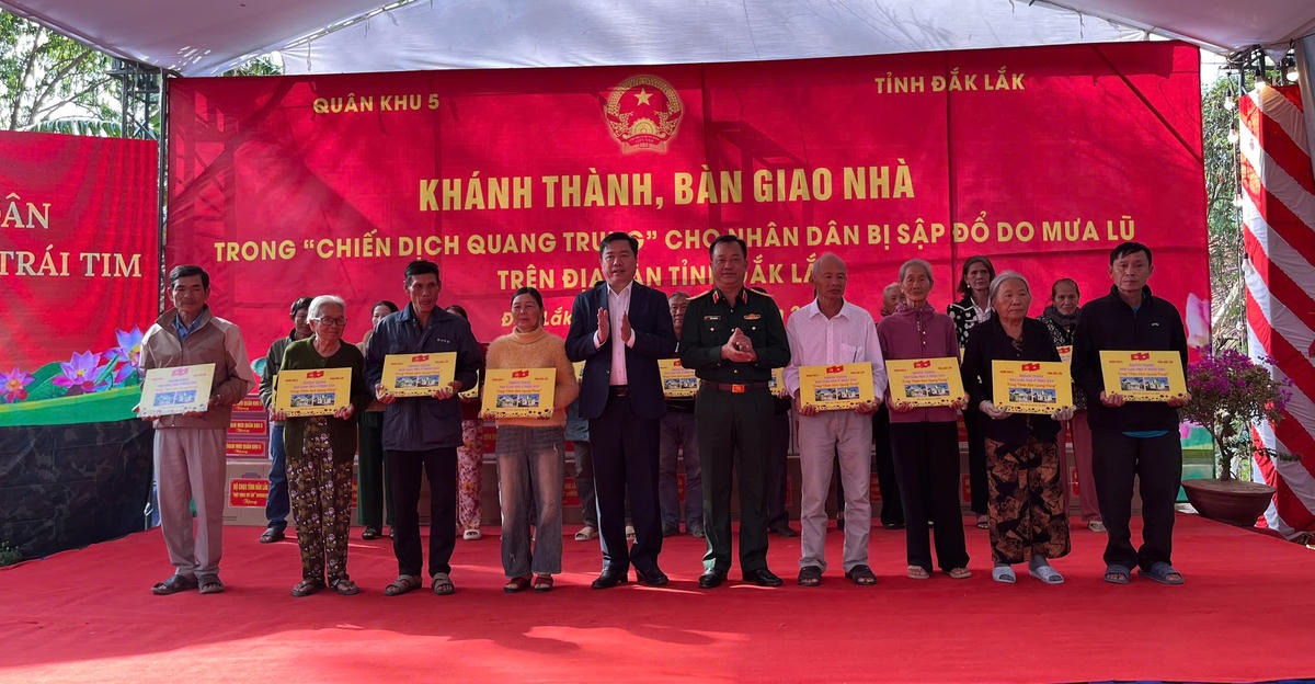Các lãnh đạo trao bảng tượng trưng bàn giao nhà cho các hộ dân. Ảnh: X.H.. 