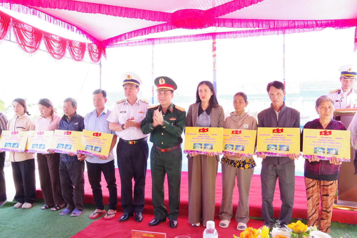 Ban tổ chức trao bảng tượng trưng bàn giao nhà cho các hộ dân. Ảnh: X.H.