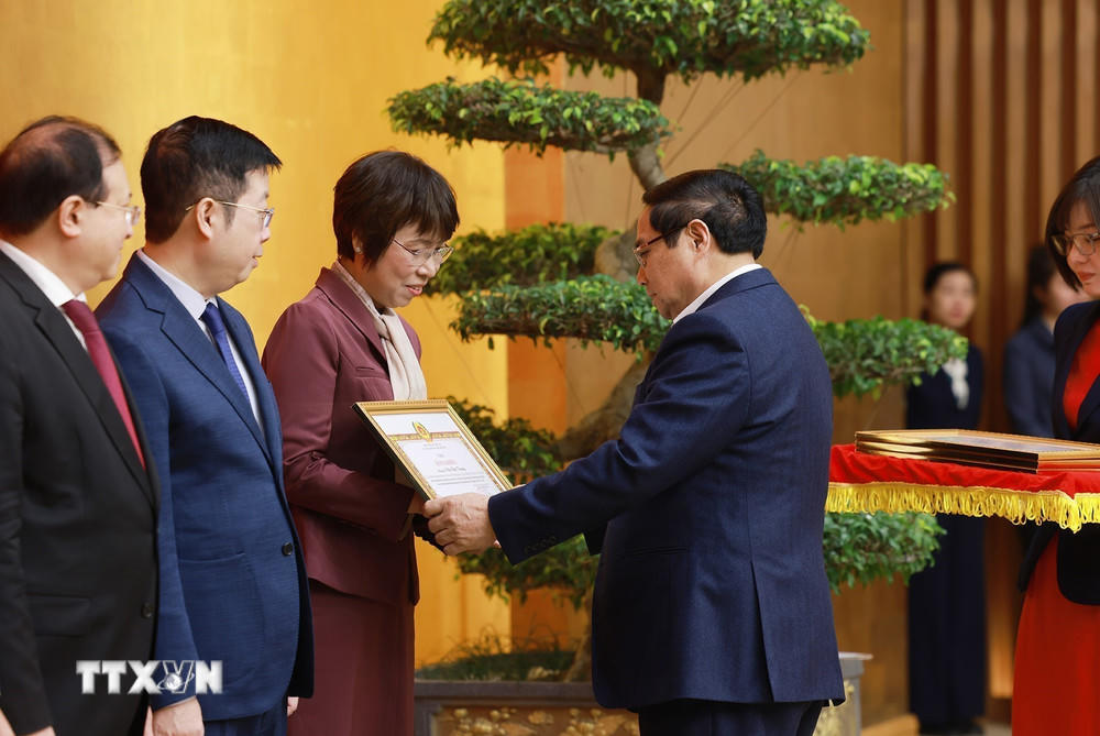 Thủ tướng Phạm Minh Chính trao Bằng khen của Ban Chấp hành Đảng bộ Chính phủ cho đồng chí Vũ Việt Trang, Tổng Giám đốc Thông tấn xã Việt Nam. (Ảnh: Dương Giang/TTXVN).