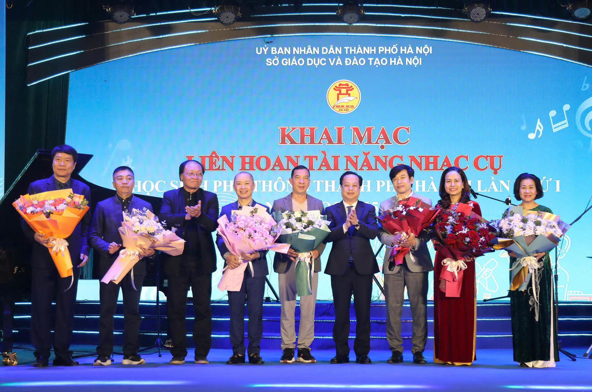 Phó Chủ tịch Thường trực HĐND thành phố Hà Nội Trần Thế Cương tặng hoa ban giám khảo liên hoan.