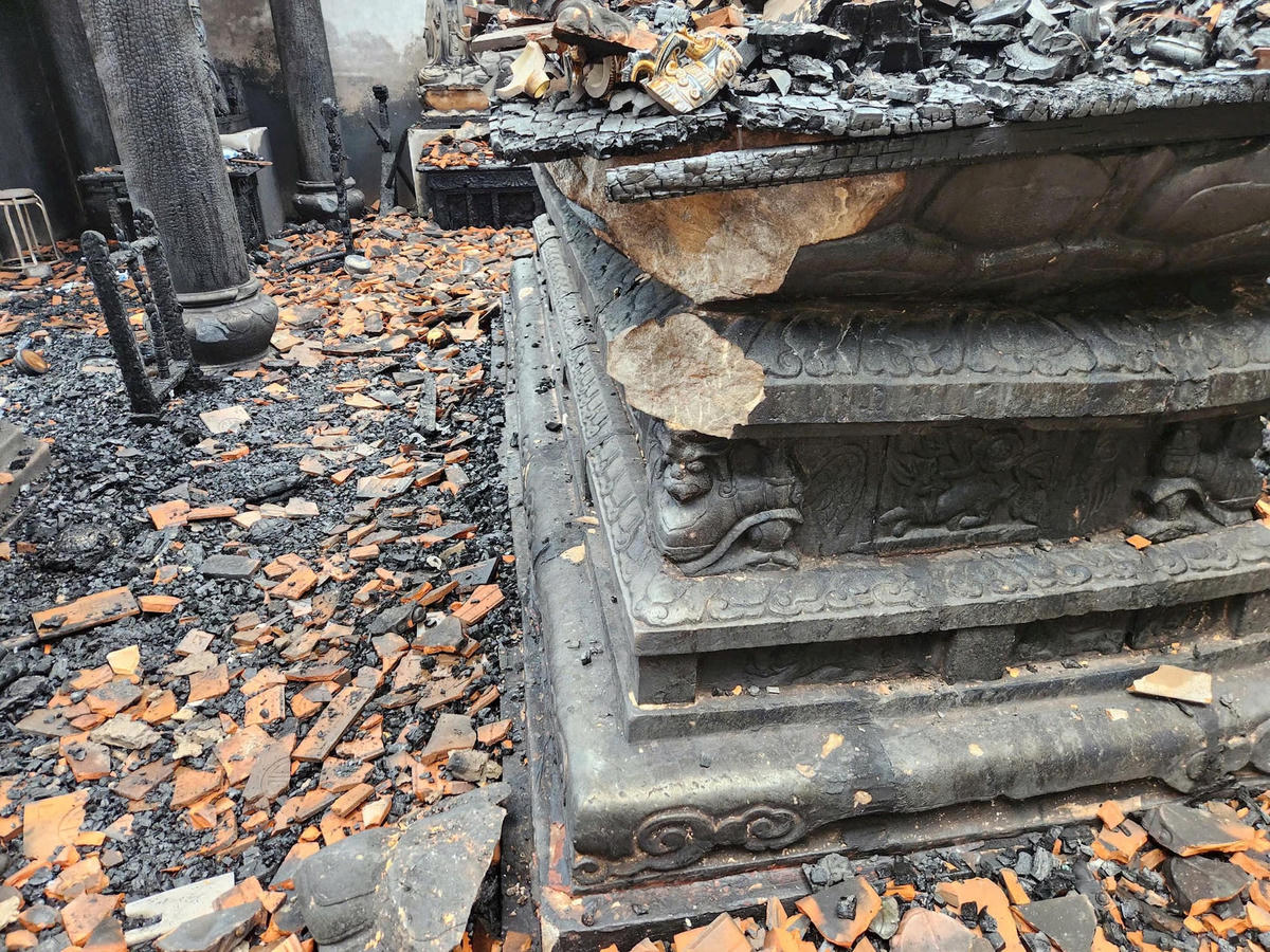 Bệ đá Hoa sen có từ thời Trần (niên đại 700 năm) bị vỡ một góc trong vụ hỏa hoạn. Ảnh Tùng Duy