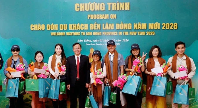 Ông Nguyễn Văn Lộc, Giám đốc Sở Văn hóa, Thể thao và Du lịch tỉnh Lâm Đồng, tặng quà lưu niệm đến những du khách đầu tiên "xông đất" du lịch tỉnh Lâm Đồng. (ảnh X.H)