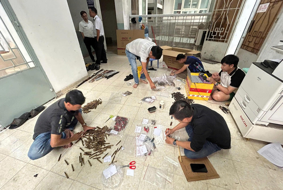 Các nghi phạm bên cạnh vũ khí và&nbsp;nguyên vật liệu để chế tạo các chi tiết súng như CZ455, CZ457, Ruger thu giữ từ đường dây. Ảnh: CA.