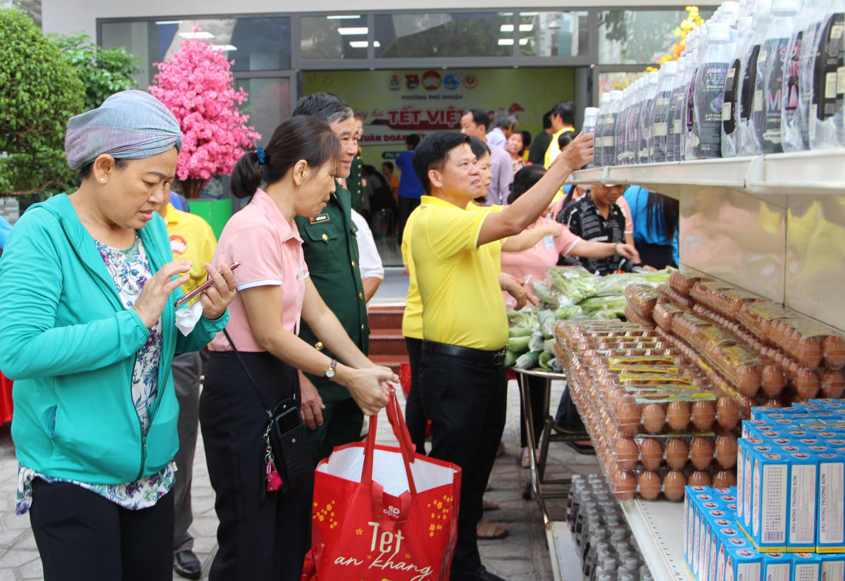 Ông Đinh Gia Huỳnh cùng lãnh đạo các tổ chức thành viên chọn quà Tết tặng bà con dự Ngày hội tại khu vực “Phiên chợ 0 đồng”. Ảnh: Q.Đ.
