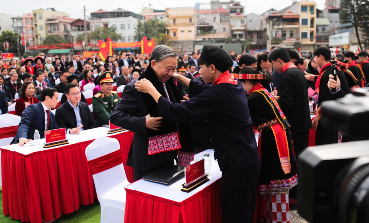 Các cháu thiếu nhi tặng Tổng Bí thư Tô Lâm khăn quàng của&nbsp;người Dao đỏ. Ảnh: Hân Nguyễn.