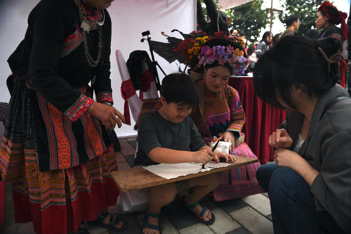 
Em nhỏ thích thú trải nghiệm vẽ sáp ong – một kỹ thuật trang trí vải truyền thống của đồng bào dân tộc Mông. Ảnh: Phạm Sỹ.
