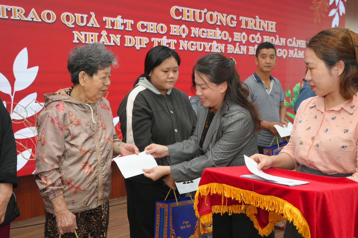 Bà Nguyễn Thị Thu Hiền, đại diện gia đình tặng quà tết cho người dân phường Hải Châu. Ảnh: Nguyễn Tú.