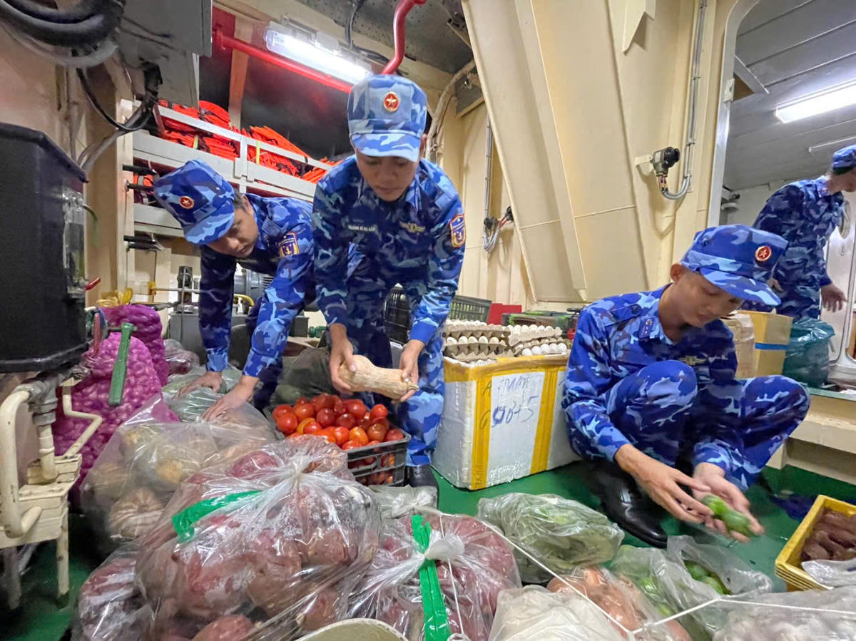 Cán bộ, chiến sĩ tàu 375 chuẩn bị lương thực, thực phẩm, hoa trang trí tết trên tàu. Ảnh: CV.