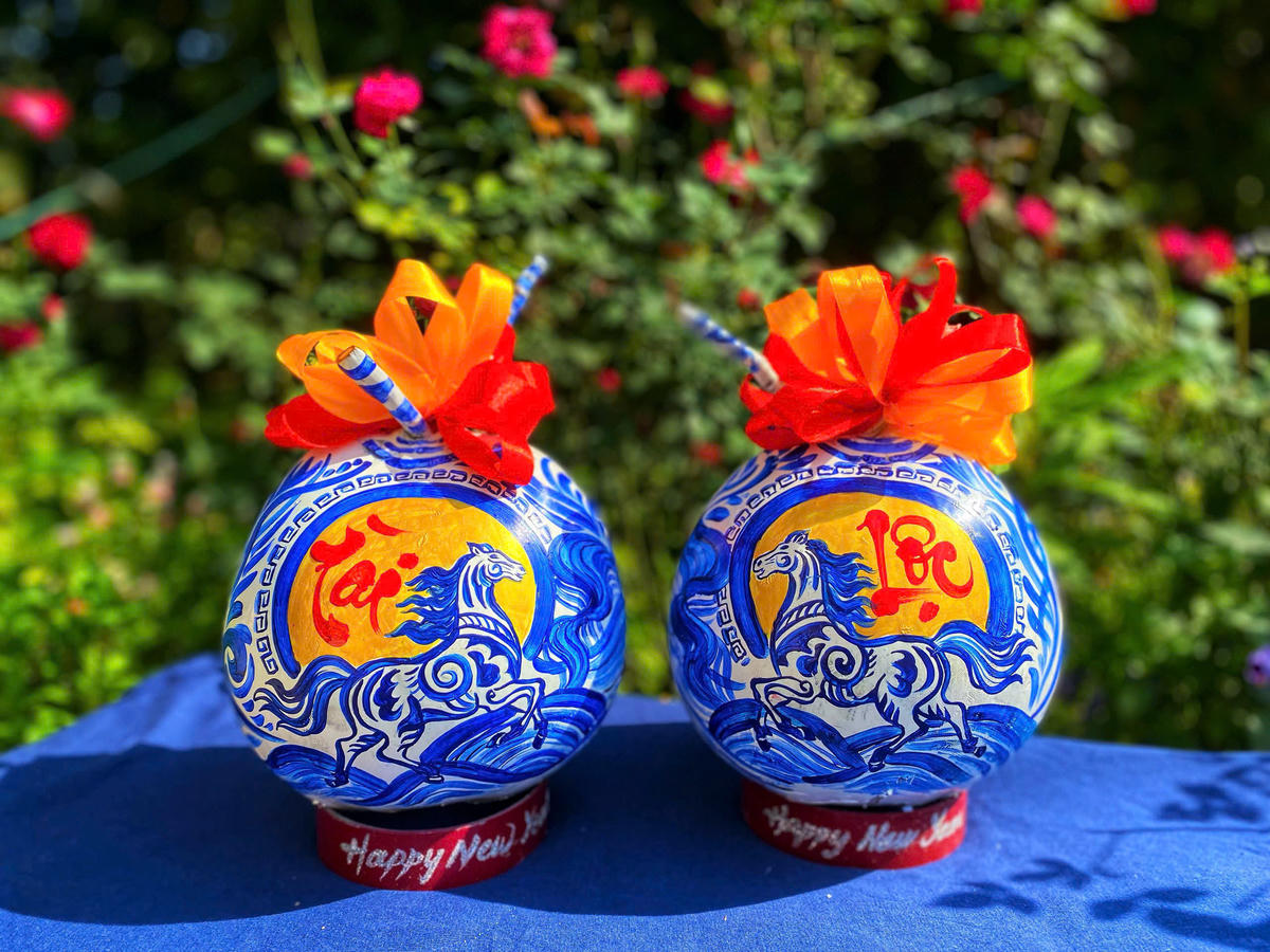 Cặp dừa vẽ linh vật ngựa và chữ thư pháp “Tài – Lộc” với màu xanh chủ đạo. Ảnh: Trung Ngãi.