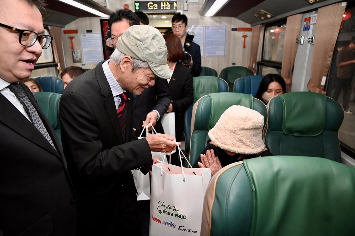 Ông Tống Văn Nga, nguyên Thứ trưởng Bộ Xây dựng, thành viên Hội đồng quản trị Công ty cổ phần xây dựng Coteccons tặng quà cho hành khách trên "Chuyến tàu Hạnh phúc".