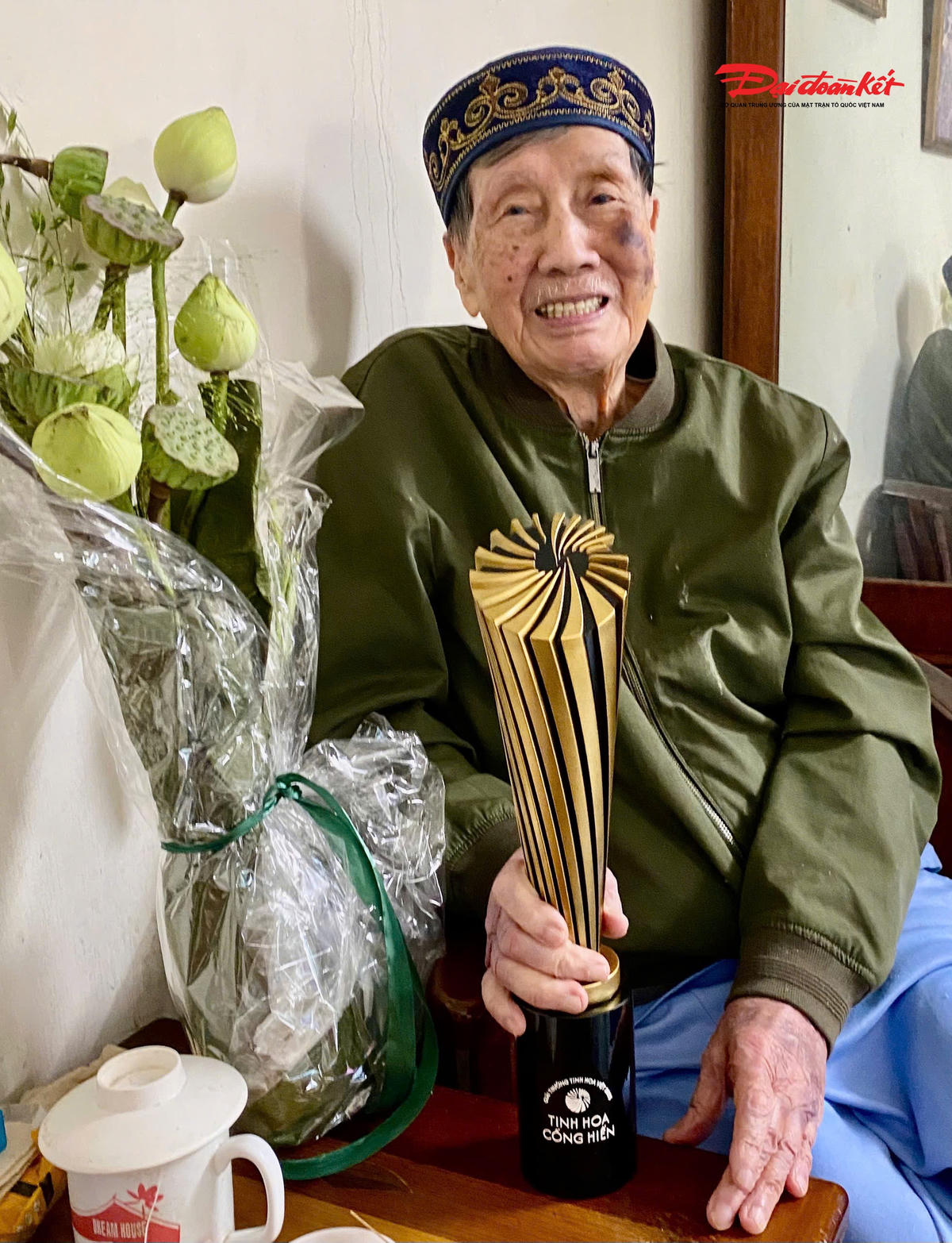 Nhạc sĩ Phạm Tuyên và chiếc cúp đặc biệt của Giải thưởng Tinh Hoa Cống Hiến. Ông khen chiếc cúp và bó sen đẹp. Ảnh: Nhà báo Phạm Hồng Tuyến