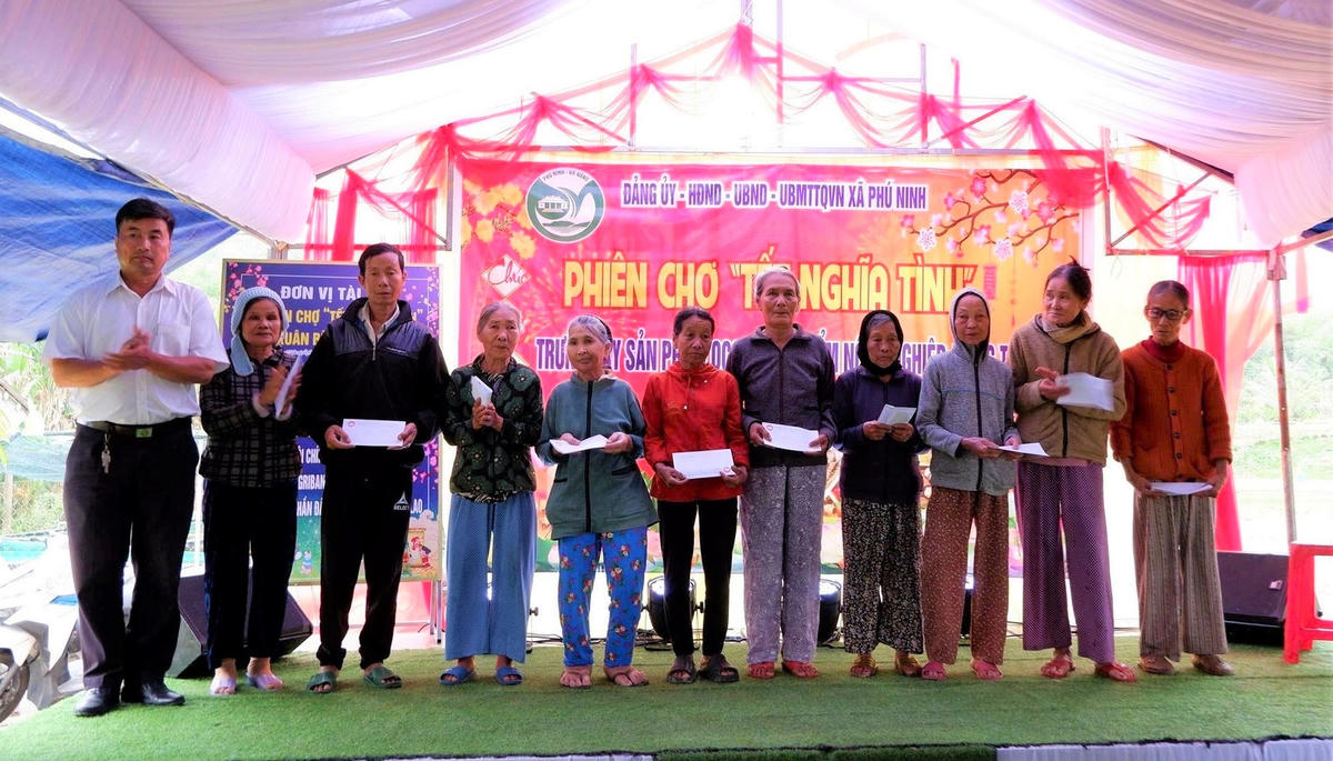 Lãnh đạo Ủy ban MTTQ Việt Nam xã Phú Ninh tặng quà cho người dân tại phiên chợ nghĩa tình. Ảnh: CV.