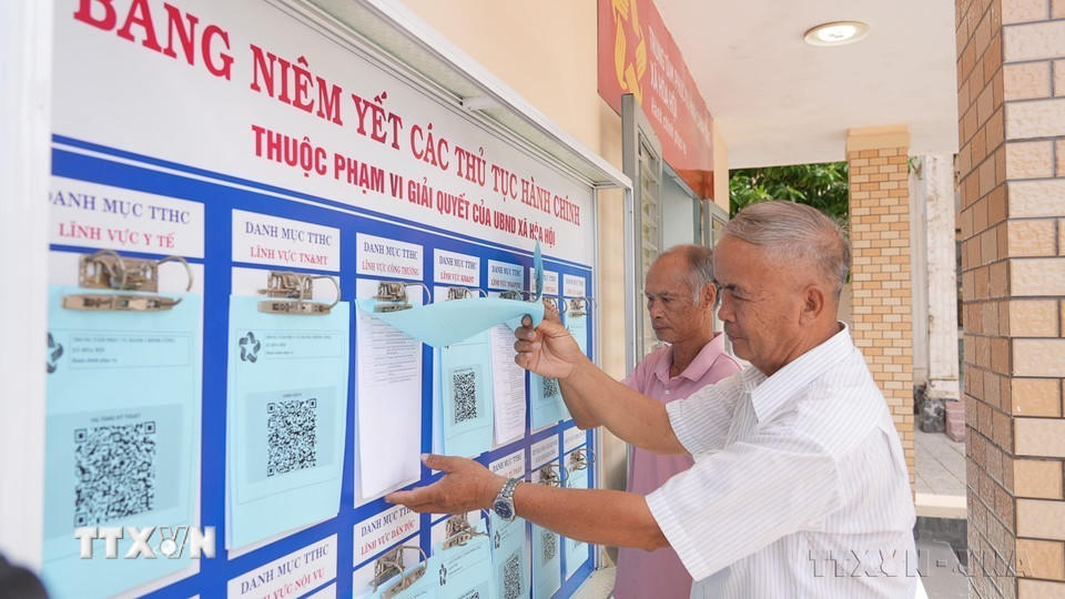 Người dân xã Hòa Hội, tỉnh Tây Ninh tra cứu thủ tục hành chính được niêm yết tại Trung tâm phục vụ hành chính công của xã (1/7/2025). (Ảnh: Minh Phú/TTXVN)