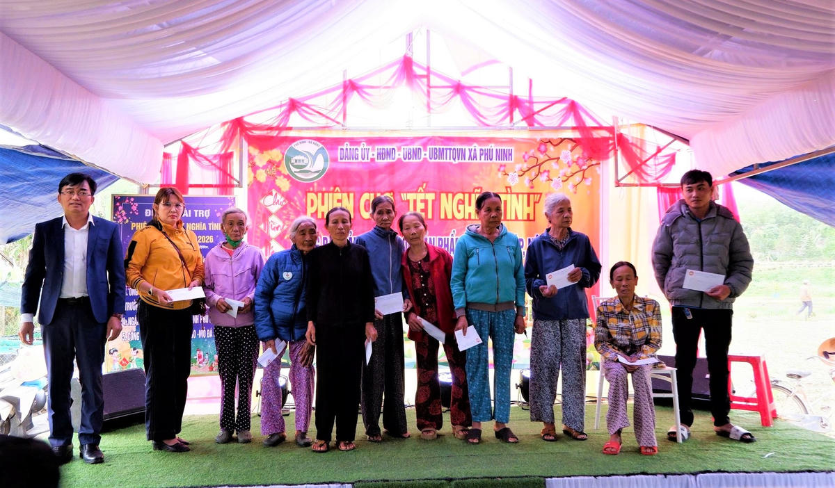 Ông Nguyễn Hữu Bình (bên trái ngoài cùng) tặng quà cho người dân tại phiên chợ Tết nghĩa tình. Ảnh: CV.