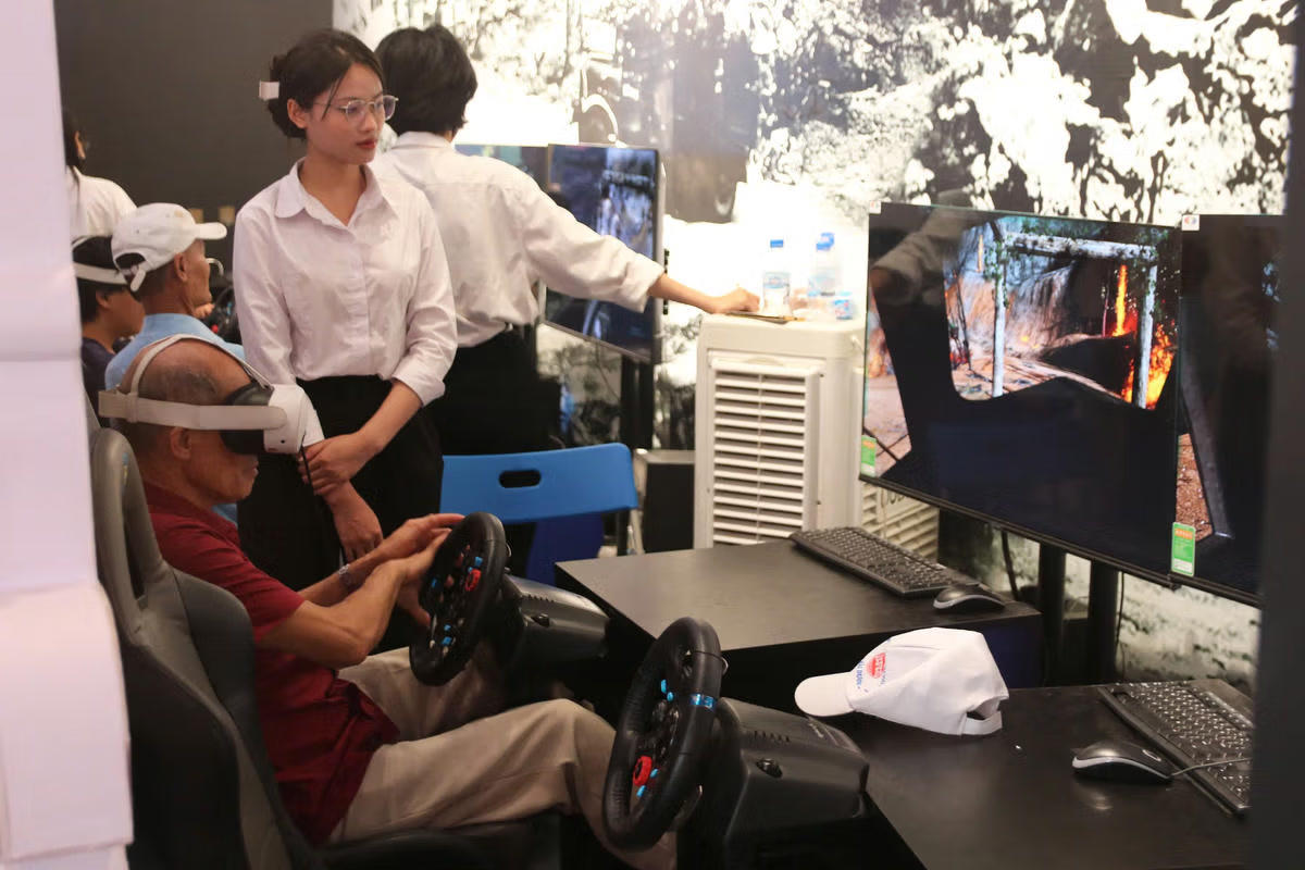 Du khách tham gia trải nghiệm phần mô phỏng lái xe không kính trên tuyến đường Trường Sơn huyền thoại. Ảnh: Tiến Đạt.