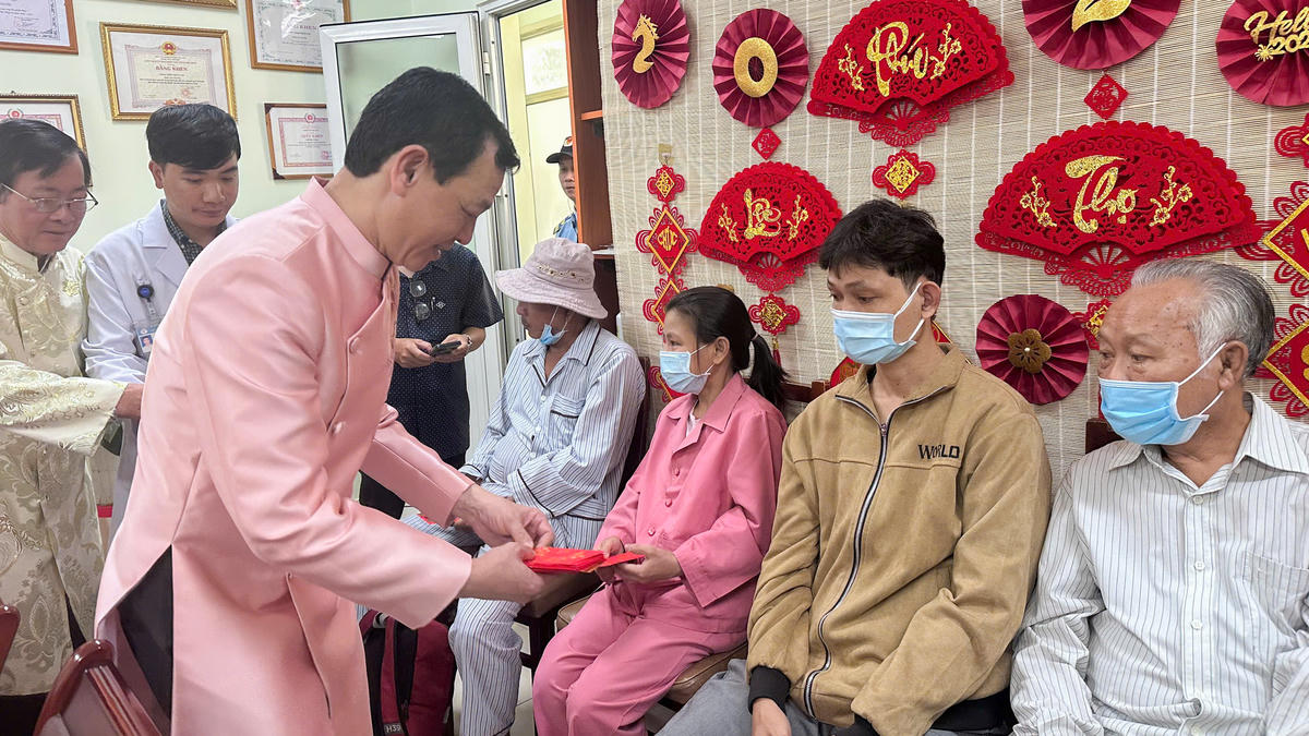 PGS. TS. BSCK2 Nguyễn Tri Thức – Thứ trưởng Bộ Y tế tặng quà cho bệnh nhân. Ảnh: BV