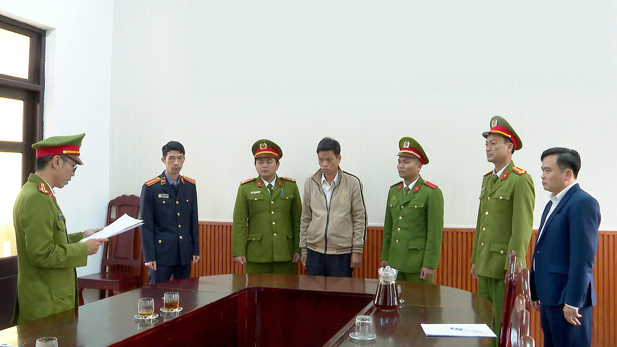 Cơ quan công an đang đọc lệnh khởi tố bị can đối với Nguyễn Đình Phương (giữa). Ảnh: P.B.. 