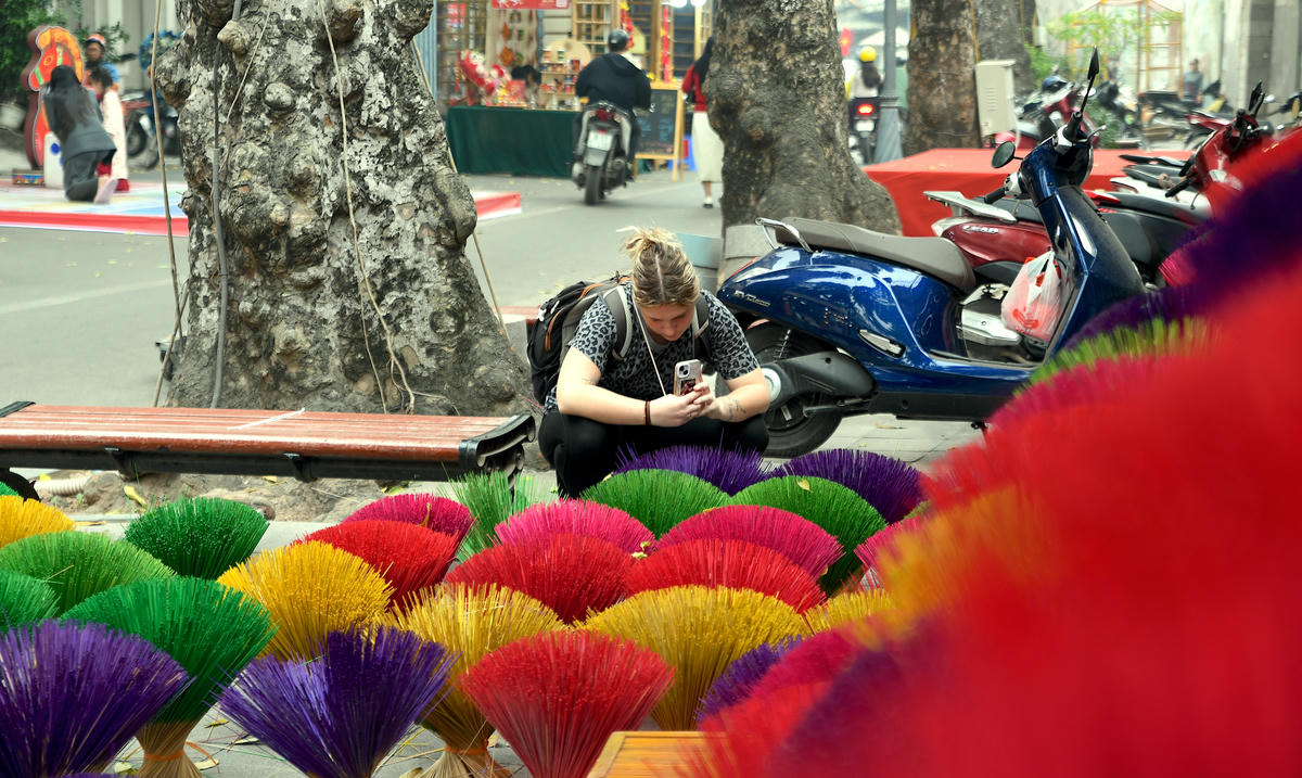 Du khách quốc tế say mê ghi lại vẻ đẹp rực rỡ, đầy sức hút của những bó hương nhiều sắc màu được trưng bày trên phố bích họa Phùng Hưng. Ảnh: Phạm Sỹ.. 