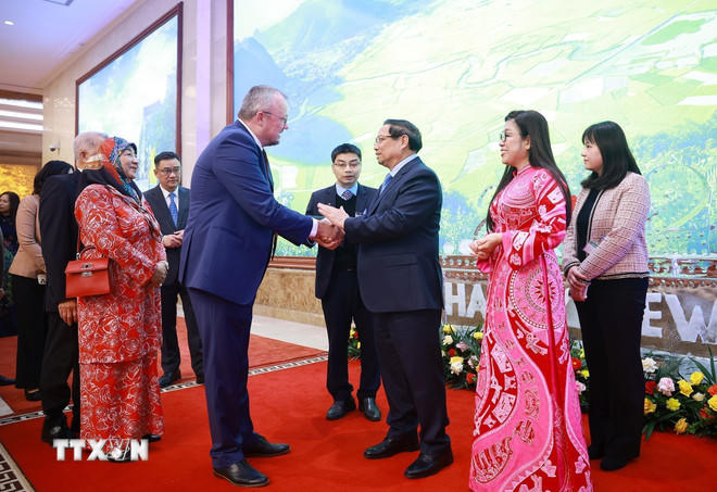 Thủ tướng Phạm Minh Chính và Phu nhân chào mừng các Đại sứ, Đại biện, Trưởng đại diện các tổ chức quốc tế tại Hà Nội cùng Phu nhân, Phu quân. (Ảnh: Dương Giang/TTXVN)