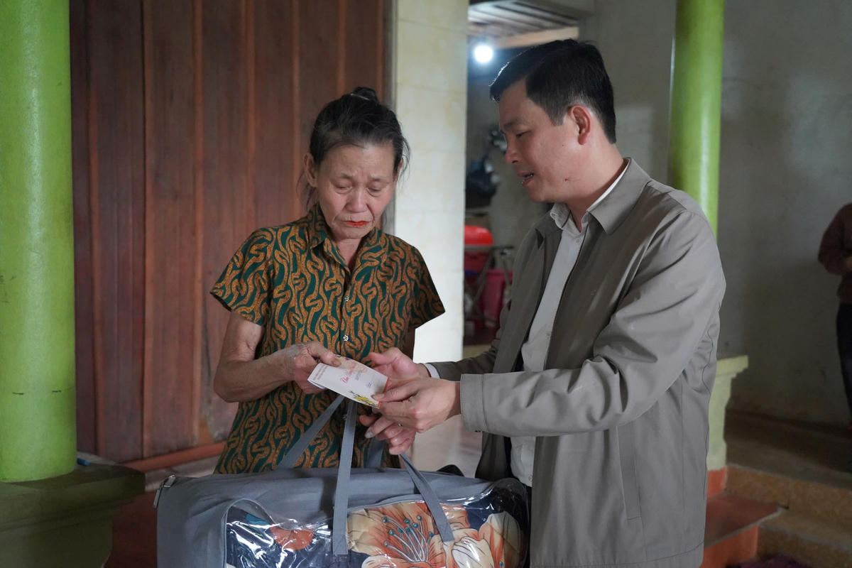 Bà Nguyễn Thị Thanh (SN 1959, trú thôn Thượng Kim, xã Sơn Kim 1) xúc động nhận tấm lòng của cán bộ Mặt trận. Ảnh: HN.