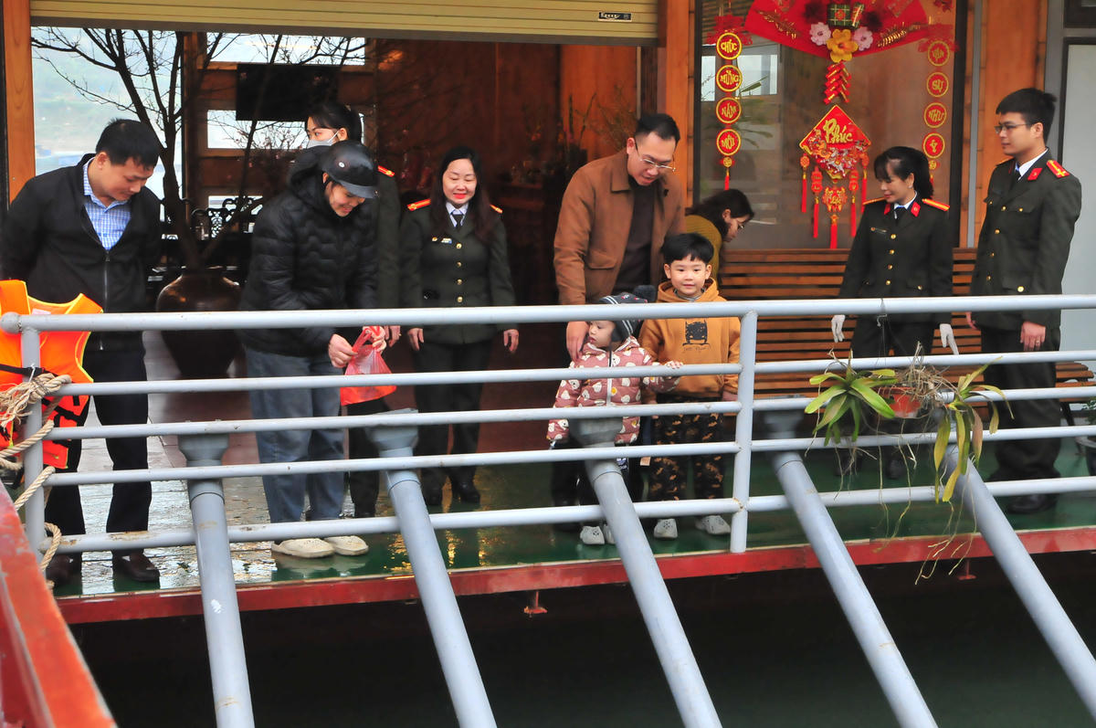 Lực lượng chức năng luôn ứng trực từ sáng sớm hướng dẫn người dân thả cá an toàn xuống sông. Ảnh: Xuân Trường.