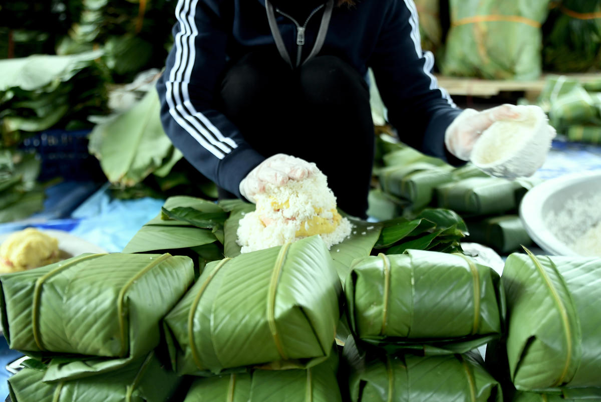  Những hạt gạo nếp tinh khôi, dẻo thơm của đất trời ôm trọn lớp nhân đầy đặn, trước khi khoác lên mình những chiếc lá dong xanh mướt. Ảnh: Phạm Sỹ.
