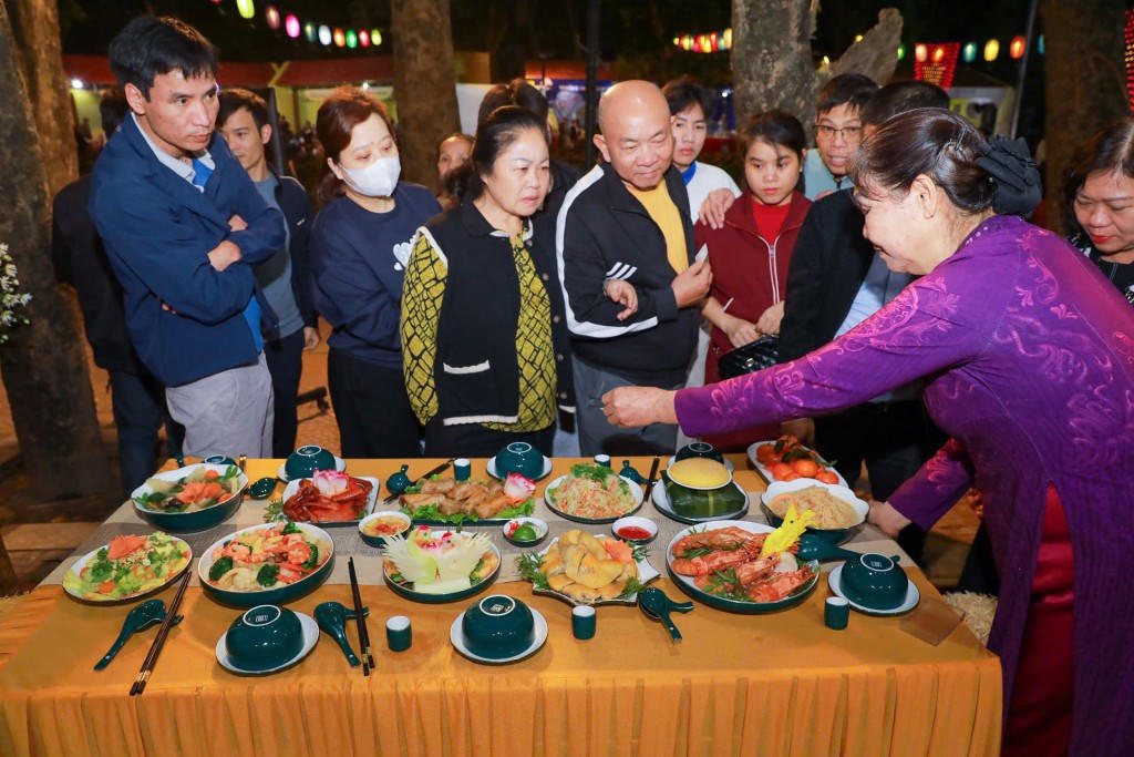 Nghệ nhân Hà Thị Vinh giới thiệu về mâm cỗ Bát Tràng.         Ảnh: Hương Thu