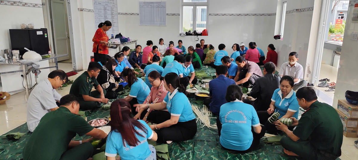 Cán bộ, chiến sĩ Đồn Biên phòng Phước Tỉnh cùng đại diện địa phương tham gia chuẩn bị nguyên liệu, tổ chức gói bánh. Ảnh: Quang Tiến.