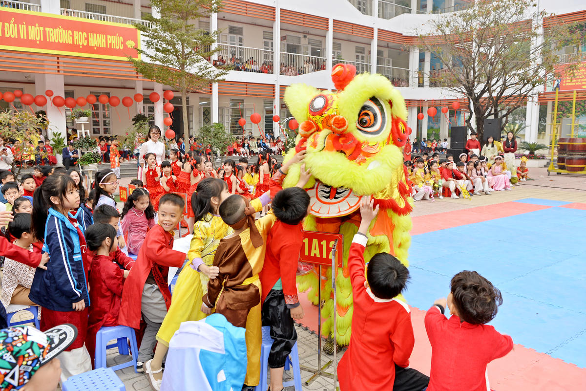 Các em học sinh hào hứng xem múa lân ở sân trường.