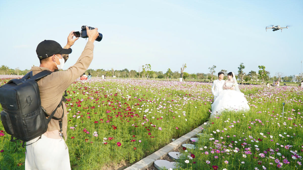 Du khách thích thú ghi lại khoảnh khắc giữa không gian rực rở sắc hoa ở vườn hoa sao nhái. Ảnh: Nguyên Du