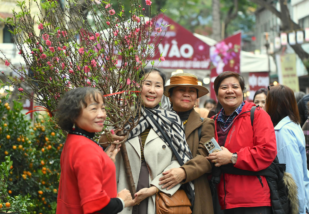 Du khách lưu giữ khoảnh khắc xuân bên những gian hoa. Ảnh: Phạm Sỹ.