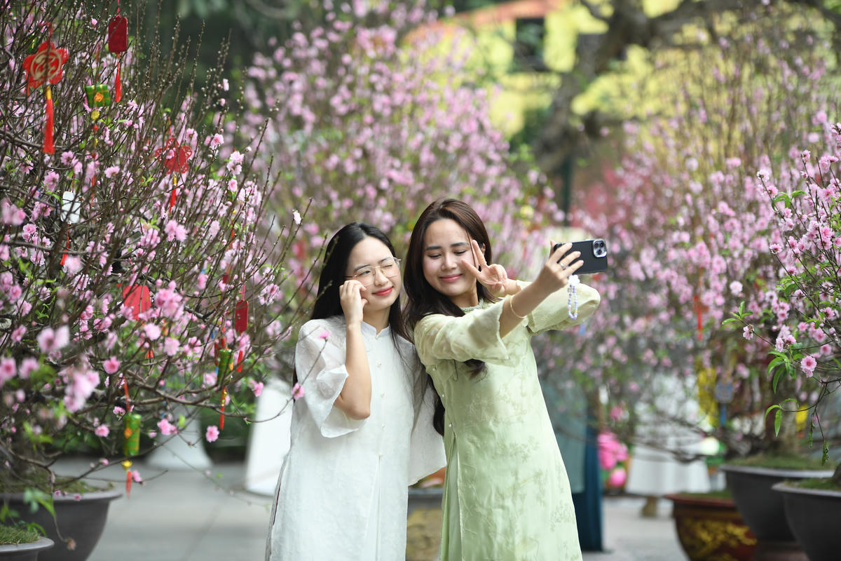 Các bạn trẻ háo hức lưu lại những khoảnh khắc tươi đẹp của mùa Xuân. Ảnh: Phạm Sỹ.