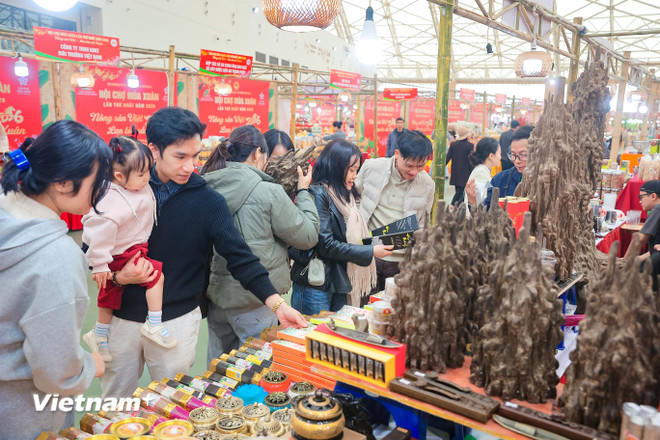 Khách hàng hào hứng tìm hiểu các mặt hàng được bày bán tại Hội chợ mùa Xuân. (Ảnh: PV/Vietnam+).