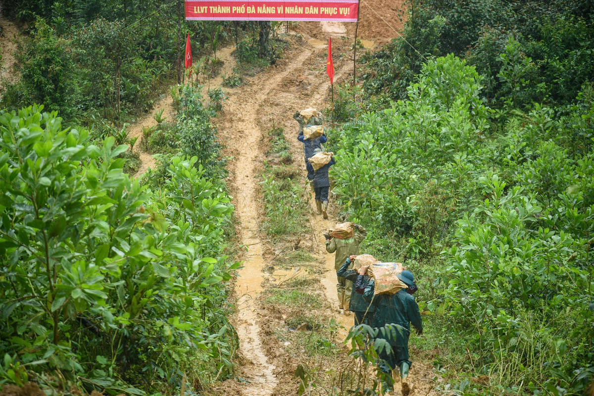 Bộ đội vượt núi băng rừng khuân vát vật liệu để làm nhà cho dân. Ảnh: Tấn Thành.