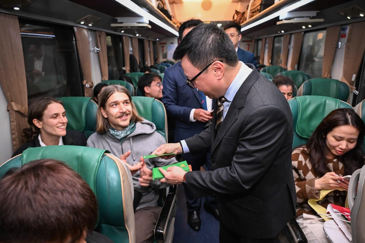 Nhà báo Lê Quốc Minh chúc mừng năm mới hành khách trên chuyến tàu.