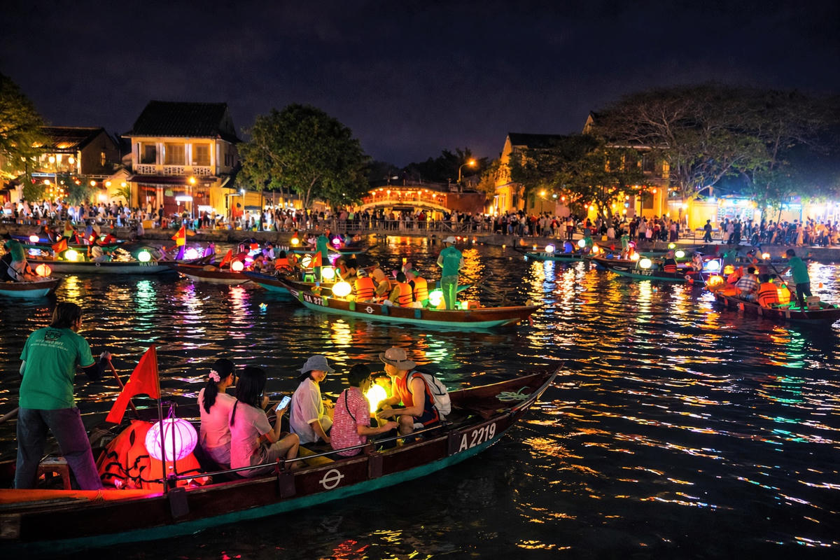 Du khách chèo ghe trên sông Hoài ngắm nhìn phố cổ Hội An. Ảnh: Tấn Thành.