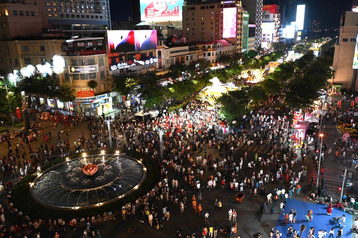Dọc tuyến phố đi bộ Đường hoa Nguyễn Huệ, dòng người nối dài từ đầu đường Lê Thánh Tôn đến bến Bạch Đằng.