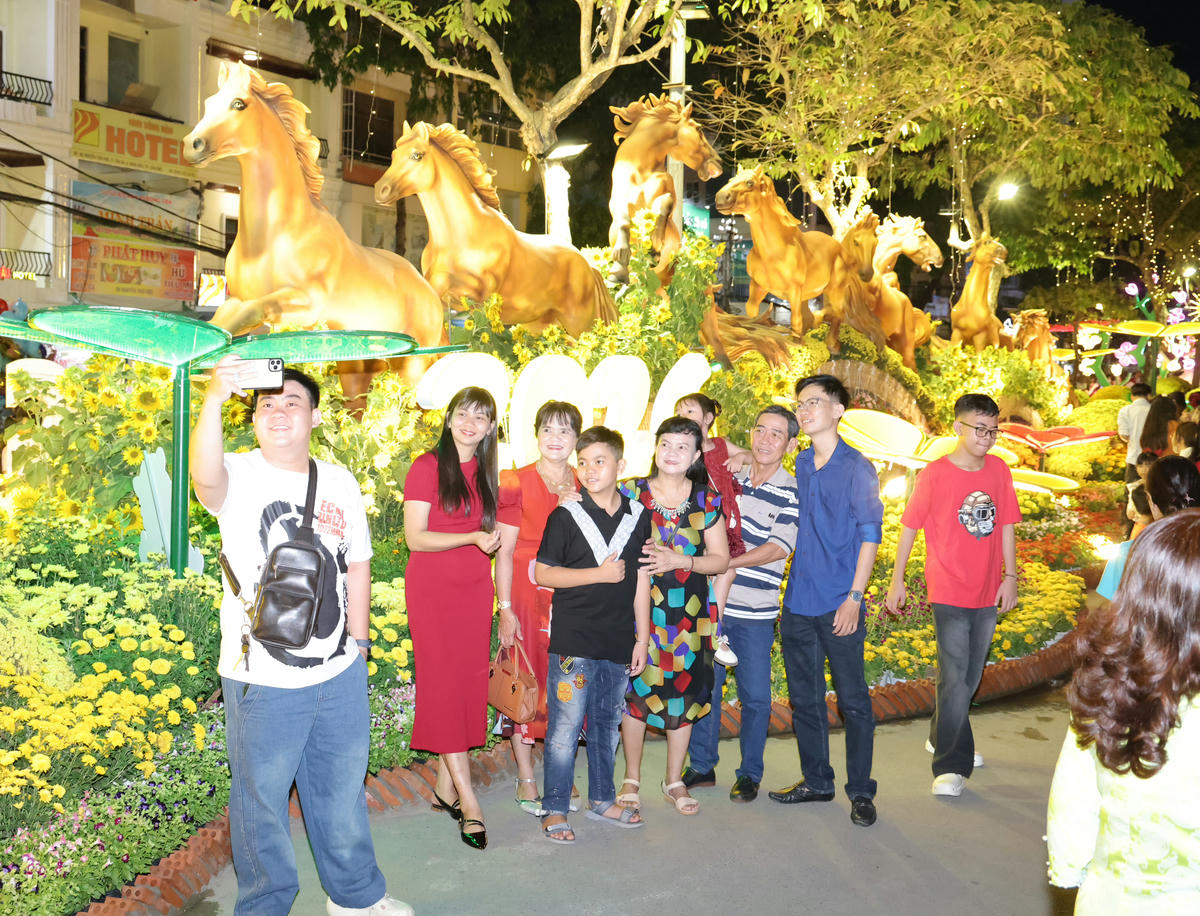 Người dân chụp ảnh, checkin tại đường hoa Cần Thơ. (ảnh: M.T).