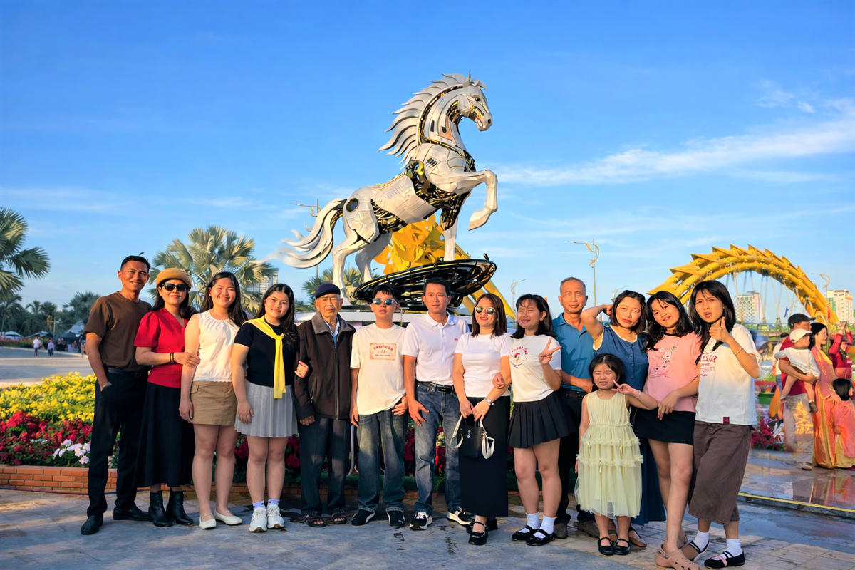 Người dân check in bên linh vật 'Kim mã 4.0' tại đường hoa Tết Đà Nẵng. Ảnh: Tấn Thành.